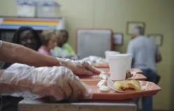A volunteer at the Community Soup Kitchen passes a serving tray down to the next section in Valdosta, Ga., Aug. 14, 2012. ?w=200&h=150
