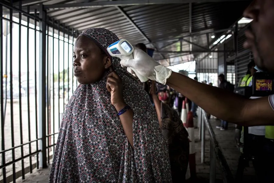 A woman gets her temperature measured at an Ebola screening station as she enters DCR from Rwanda. ?w=200&h=150