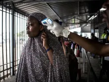 A woman gets her temperature measured at an Ebola screening station as she enters DCR from Rwanda. 