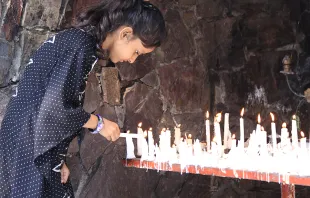 A young girl lights a candle at a Marian Grotto in Pakistan. Magdalena Wolnik/CNA.