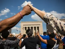 Activisits hold hands during rally lead by faith leaders in front of Baltimore City Hall on May 3, 2015 in Baltimore, Maryland. 