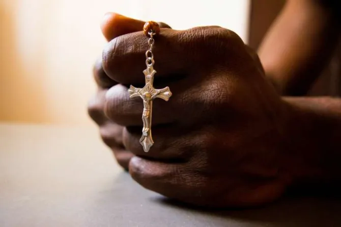 African man praying rosary Credit Red Confidential Shutterstock CNA