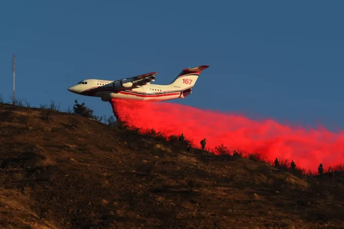 An air tanker drops fire retardant over power lines while helping to fight the Hillside Fire in San Bernardino California Oct 31 2019 Credit Josh Edelson AFP via Getty 