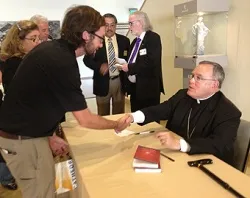 Archbishop Charles Chaput signs copies of his book in the cathedral conference center lobby following the LA Prayer Breakfast. ?w=200&h=150