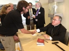 Archbishop Charles Chaput signs copies of his book in the cathedral conference center lobby following the LA Prayer Breakfast. 