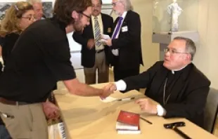 Archbishop Charles Chaput signs copies of his book in the cathedral conference center lobby following the LA Prayer Breakfast.   Archdiocese of Los Angeles.