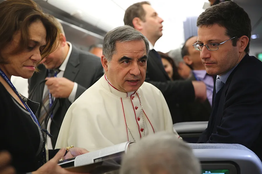 Then-Archbishop Giovanni Angelo Becciu speaks with journalists aboard the papal flight to Colombo, Jan. 12, 2015. Becciu was made a cardinal June 28, 2018. ?w=200&h=150