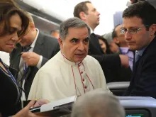 Then-Archbishop Giovanni Angelo Becciu speaks with journalists aboard the papal flight to Colombo, Jan. 12, 2015. Becciu was made a cardinal June 28, 2018. 