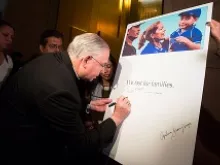 Archbishop José H. Gomez of Los Angeles signs a board showing his commitment to fasting for families, Nov. 26, 2013. 