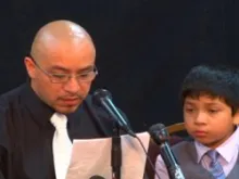 Arturo Martinez-Sanchez reads a statement at the press conference with one of his sons. Photo used with permission.