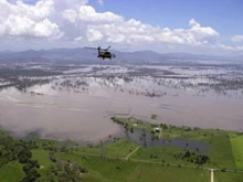 An Australian Army helicopter flies over flooded Queensland. Courtesy of the Commonwealth of Australia