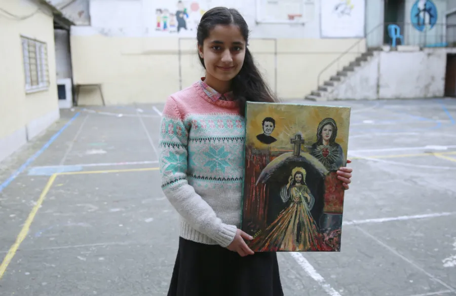 Syrian refugee Sarah, 14, displays a painting she made for Pope Francis. ?w=200&h=150
