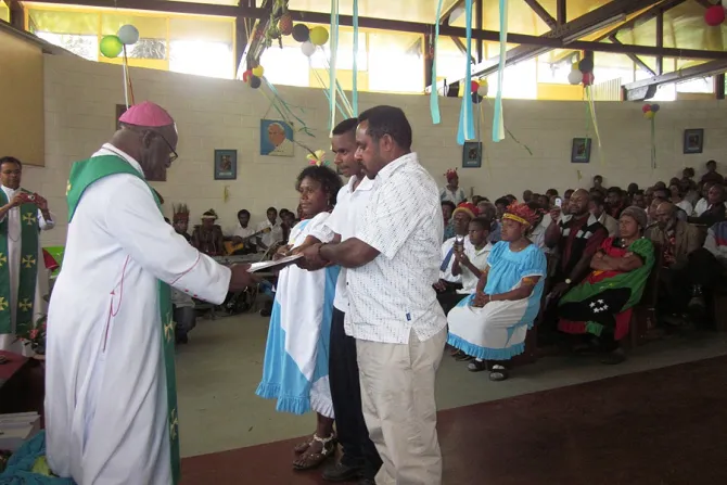 Bishop Otto Separi of Aitape hands over a copy of the new Pastoral Plan for Papua New Guineai and Solomon Islands to a family in Goroka Photo courtesy of Fr Giorgio Licini CNA 10 9 14