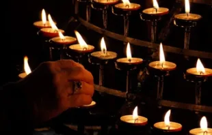 A believer lights a candle.   Petr Kratochvil.
