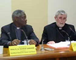 Cardinal Peter K.A. Turkson, president of the Pontifical Council for Justice and Peace listens as Aux Bishop Patrick Lynch of Southwark, England speaks.?w=200&h=150