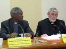 Cardinal Peter K.A. Turkson, president of the Pontifical Council for Justice and Peace listens as Aux Bishop Patrick Lynch of Southwark, England speaks.