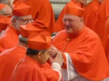Cardinal Timothy M. Dolan is greeted by his brother cardinals at the Feb. 18, 2012 consistory in St. Peter's Basilica. CNA file photo.