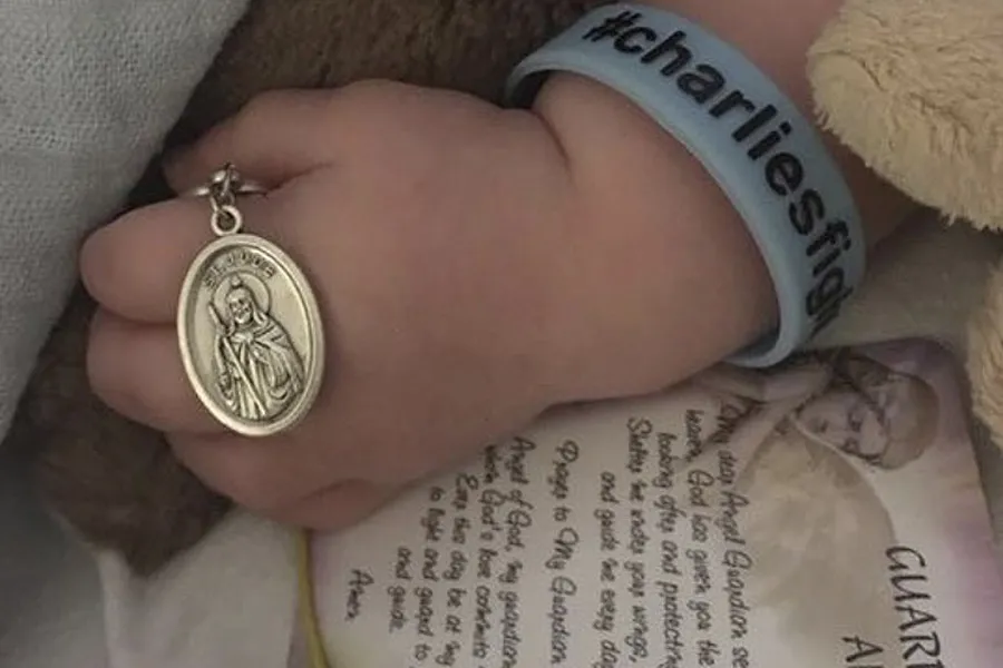 Charlie Gard holds metal of St. Jude. ?w=200&h=150