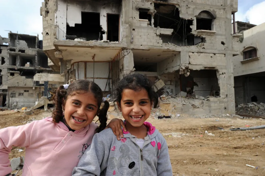 Children amid devastated buildings in Gaza. ?w=200&h=150