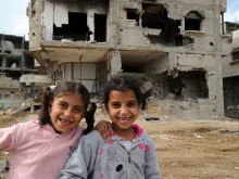 Children amid devastated buildings in Gaza. 
