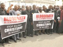 Christians hold signs as they march on the streets of Abuja during prayer and penance for peace and security in Nigeria on March 1, 2020.