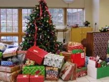 Donated gifts stand under a tree during a Christmas gift drive.