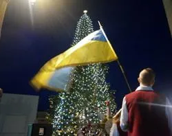 A member of the choir waves the Ukrainian flag during the lighting of the Christmas tree in St. Peter's Square?w=200&h=150