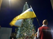 A member of the choir waves the Ukrainian flag during the lighting of the Christmas tree in St. Peter's Square