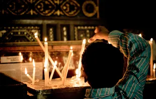Coptic Christian boy lights a candle at a church in Cairo.   Christopher Rose via Flickr CC BY NC 2.0.