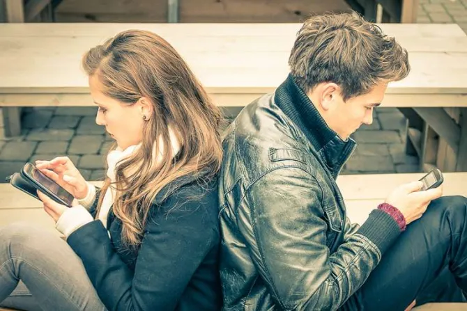 Couple looking at phones Credit View Apart Shutterstock CNA