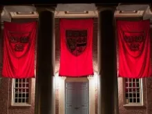 Crimson banners hang outside Memorial Church on the campus of Harvard University in Cambridge, Mass., Sept. 6, 2012. 