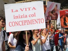 Pro-life witnesses participate in Rome's March for Life, May 10, 2015. THe sign reads "life begins at conception." 