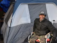 Mike Harris, who was one of the people displaced from K Street, poses for a picture in front of his tent under L Street. 