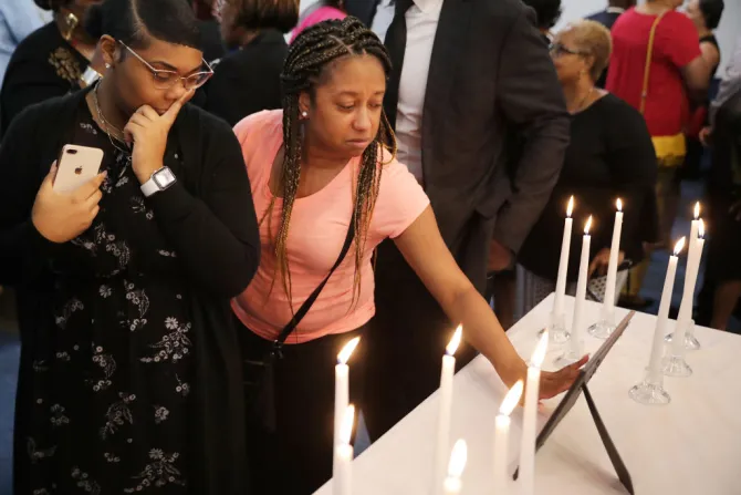 Dashae Wade L and Candace Grimes touch a photograph during a memorial service at Piney Grove Baptist Church June 02 2019 in Virginia Beach Va Credit Chip Somodevilla Getty Images