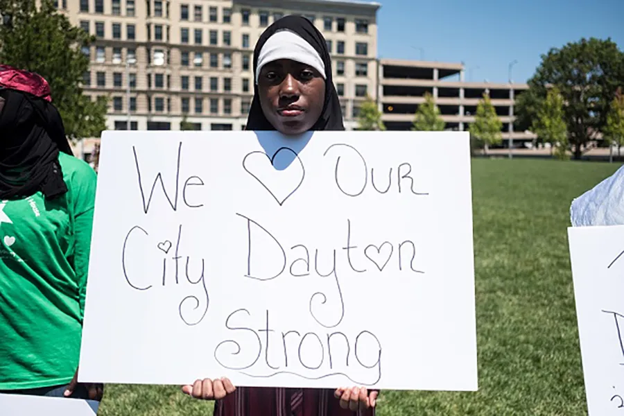 A woman holds a sign at a vigil in honor of those who lost their lives during a shooting in Dayton, Ohio on August 04, 2019. ?w=200&h=150