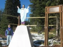 Dr. Raymond Leopold stands next to the 10th Mountain Division war memorial known as the Montana Jesus Statue. 
