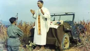 Father Emil Kapaun celebrating Mass using the hood of a jeep as his altar, Oct. 7, 1950. Public domain.