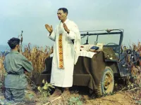 Father Emil Kapaun celebrating Mass using the hood of a jeep as his altar, October 7, 1950. Public domain.