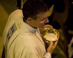A priest distributes communion. ?w=200&h=150