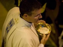 A priest distributes communion. 