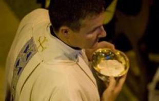 A priest distributes communion.   Mazur