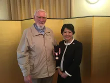 Father Jude McKenna holds his Order of the Rising Sun award alongside Japan's Ambassador to the Republic of Ireland, Mari Miyoshi. 