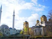 A church and a mosque adjacent one another in Ferizaj, Kosovo. 