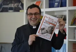 Fr. Andrea Ciucci holds a flyer for Pope Francis' Sept. 28 audience with elderly and grandparents. ?w=200&h=150