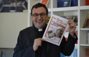Fr. Andrea Ciucci holds a flyer for Pope Francis' Sept. 28 audience with elderly and grandparents.   Daniel Ibañez/CNA.