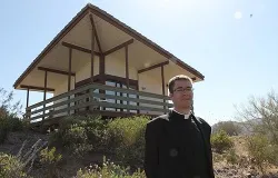 Fr. Eugene Florea stands in front of the newly built hermitages. ?w=200&h=150