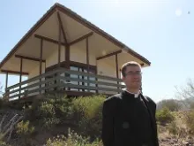 Fr. Eugene Florea stands in front of the newly built hermitages. 