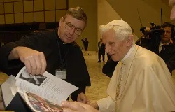 Fr. John Phalen, CSC, presents a book with the names of 80,000 people who pledged to pray the Rosary daily to the Pope in December. ?w=200&h=150