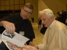 Fr. John Phalen, CSC, presents a book with the names of 80,000 people who pledged to pray the Rosary daily to the Pope in December. 