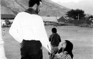 Fr. Rother with a young child.   Frankie Williams. Courtesy of the Archdiocese of Oklahoma City Archives.